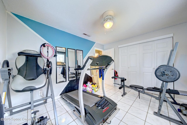 workout area with light tile patterned floors and ceiling fan