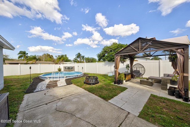 view of patio featuring a gazebo, a fenced in pool, and an outdoor living space with a fire pit