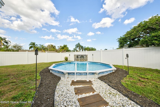 view of swimming pool with a lawn