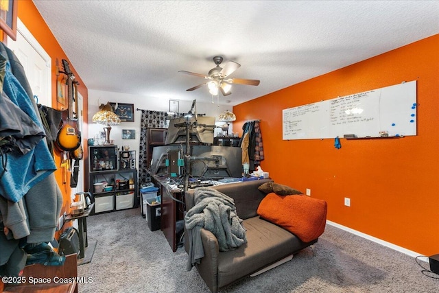 interior space with a textured ceiling, carpet flooring, a ceiling fan, and baseboards