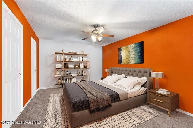 carpeted bedroom featuring a ceiling fan, baseboards, and a textured ceiling