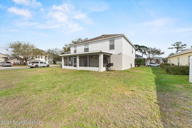 rear view of house featuring a residential view, a sunroom, and a lawn