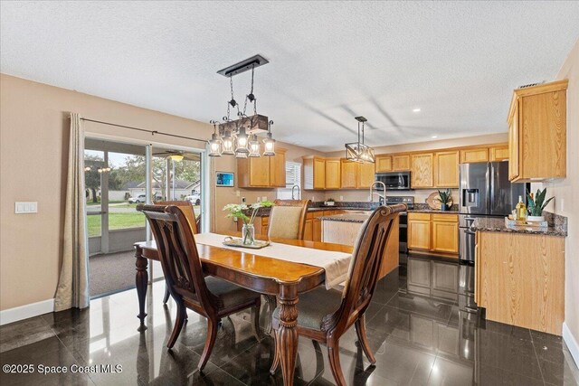 dining area featuring a textured ceiling, recessed lighting, and baseboards