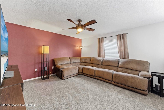 living area featuring a textured ceiling, carpet floors, a ceiling fan, and baseboards