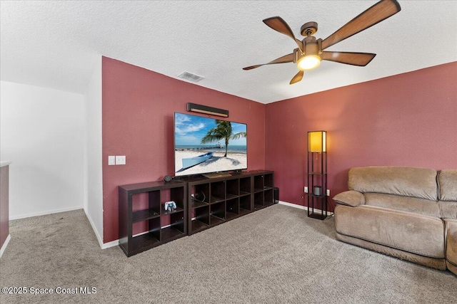 carpeted living area featuring a ceiling fan, visible vents, a textured ceiling, and baseboards