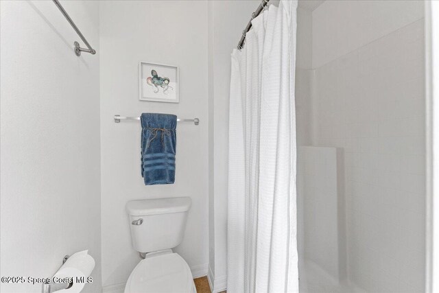 full bathroom featuring toilet and a shower stall