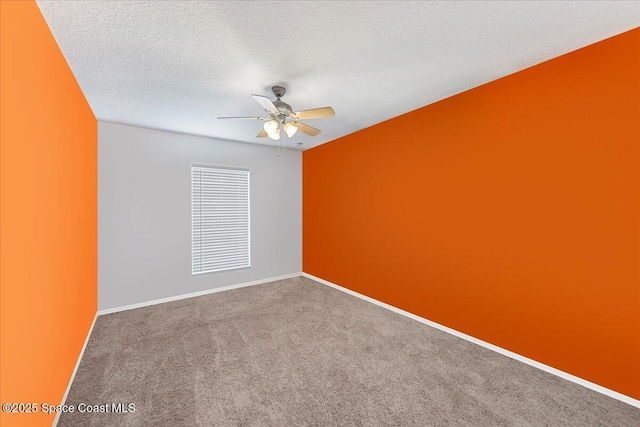 empty room with a ceiling fan, carpet flooring, a textured ceiling, and baseboards