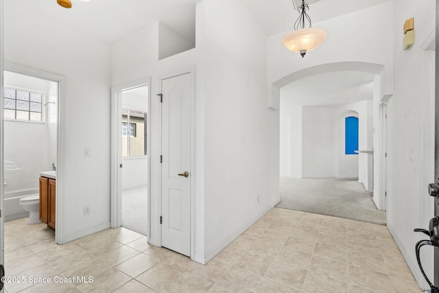 hall with light colored carpet