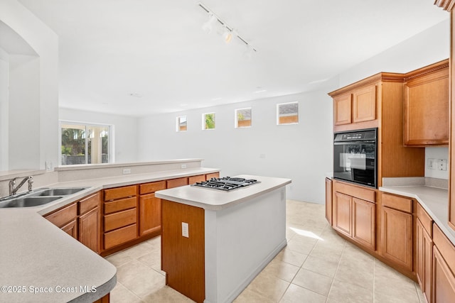 kitchen with light tile patterned flooring, sink, a center island, black oven, and stainless steel gas stovetop