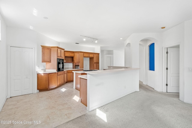 kitchen featuring gas stovetop, light tile patterned floors, and black oven