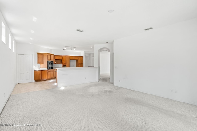 unfurnished living room featuring light carpet