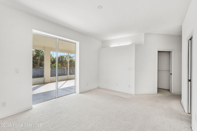 spare room featuring light colored carpet