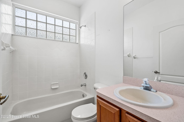 full bathroom with tiled shower / bath, vanity, and toilet