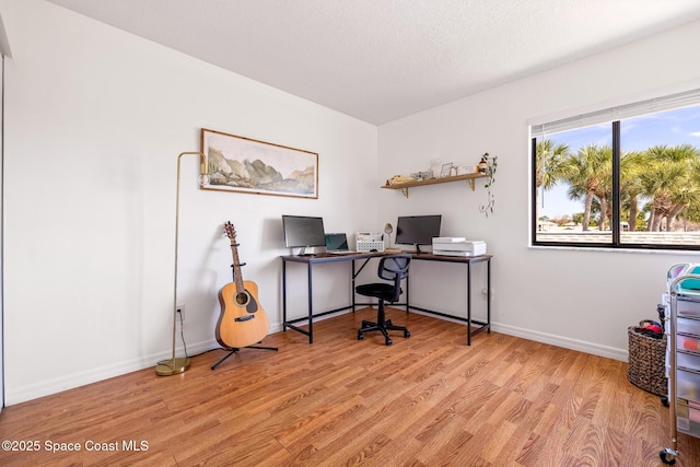 office area with a textured ceiling and light wood-type flooring