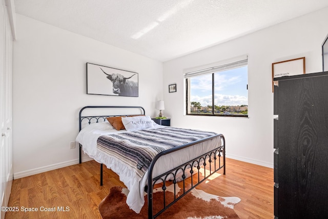 bedroom featuring light hardwood / wood-style flooring and a textured ceiling