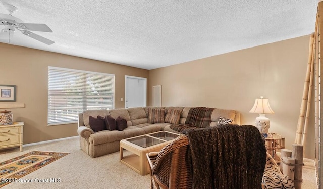 living room featuring ceiling fan, light carpet, and a textured ceiling