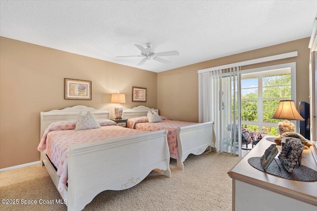 bedroom with ceiling fan, light colored carpet, and a textured ceiling