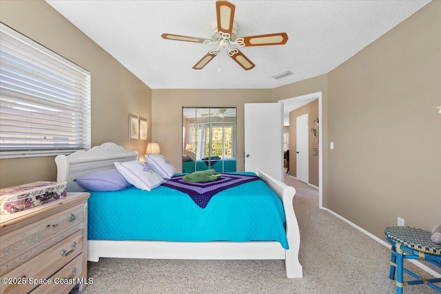 carpeted bedroom with ceiling fan and a textured ceiling