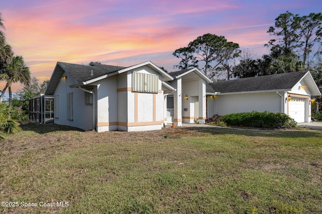 view of front of home with a garage and a yard