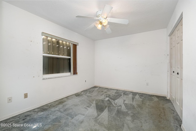 carpeted spare room with ceiling fan and a textured ceiling