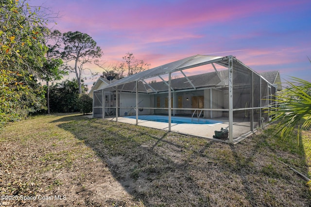 exterior space featuring a lanai, a patio area, and a lawn