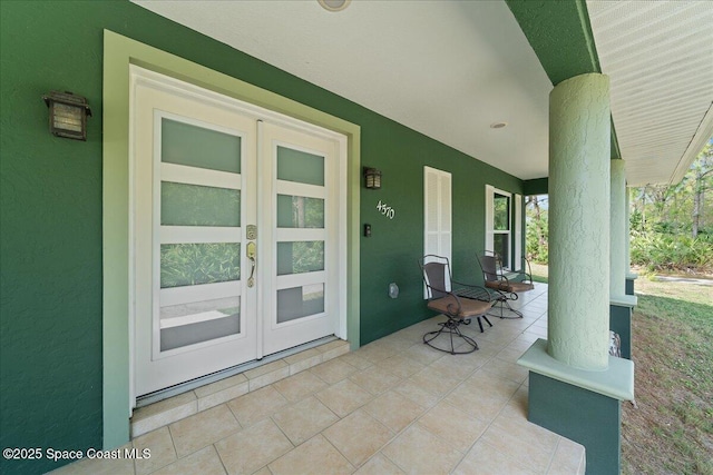 view of patio featuring a porch and french doors