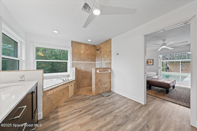 bathroom with hardwood / wood-style flooring, ceiling fan, vanity, and separate shower and tub