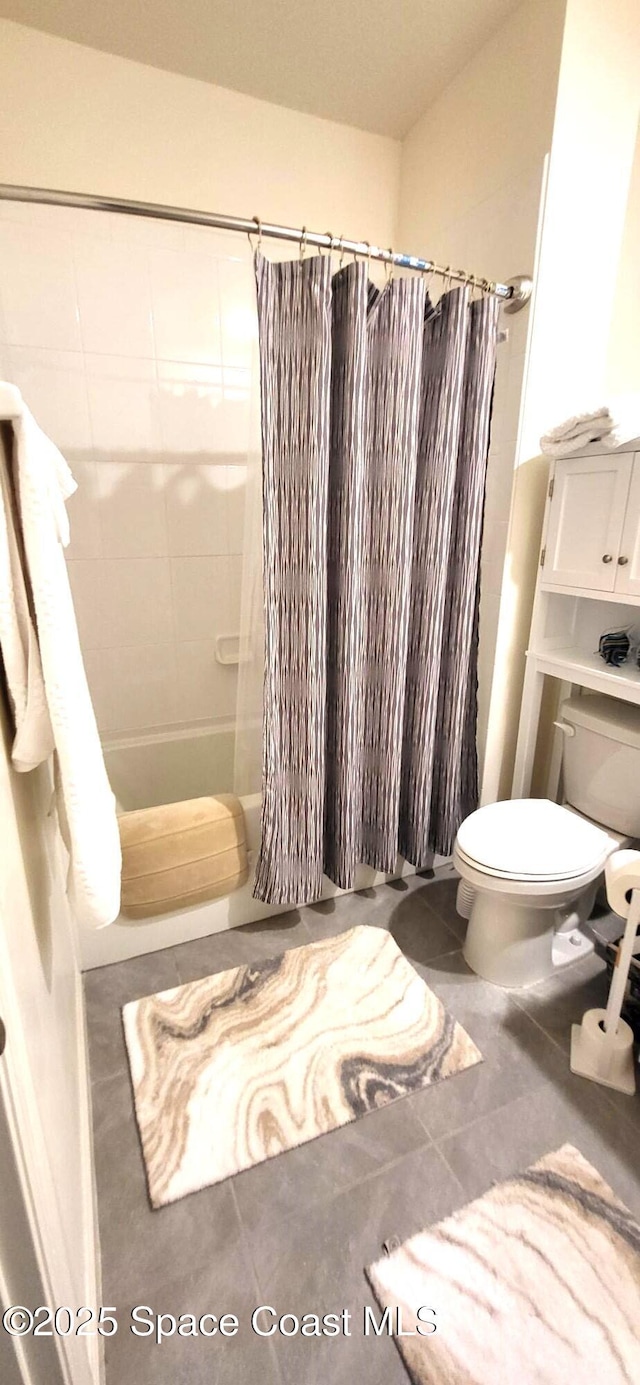 bathroom with shower / tub combo with curtain and toilet