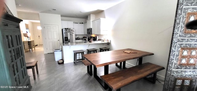 dining room featuring sink and dark tile patterned flooring