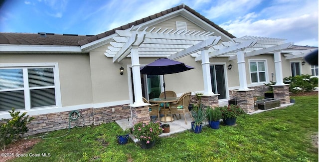 rear view of house featuring a pergola, a lawn, and a patio area