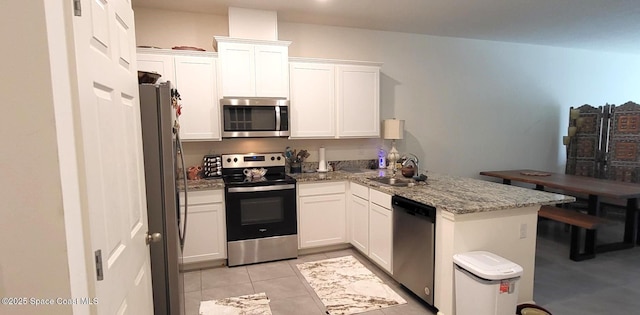 kitchen featuring sink, stainless steel appliances, white cabinets, and light stone countertops