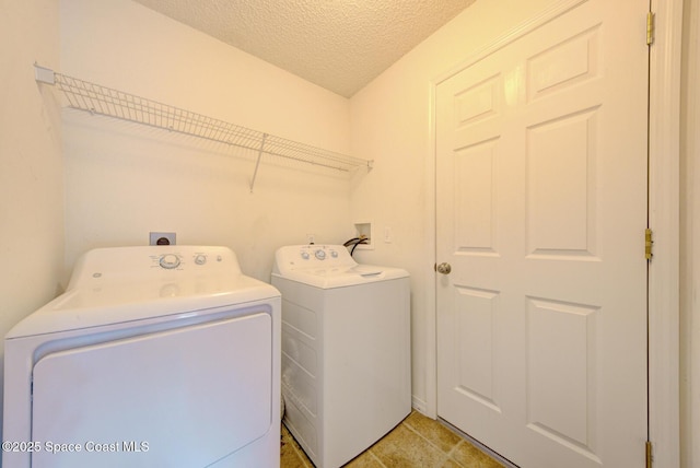 clothes washing area with washer and dryer and a textured ceiling