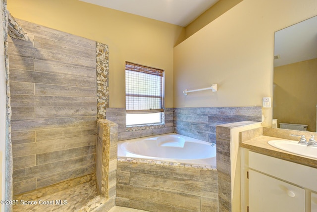 bathroom with vanity and tiled tub