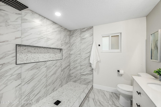 bathroom with vanity, a textured ceiling, and a tile shower