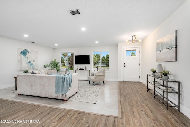 living room with light hardwood / wood-style floors and a chandelier