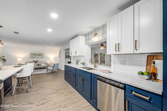 kitchen featuring blue cabinets, dishwasher, sink, and white cabinets