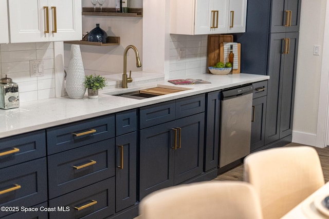 kitchen with white cabinetry, dishwasher, sink, and backsplash