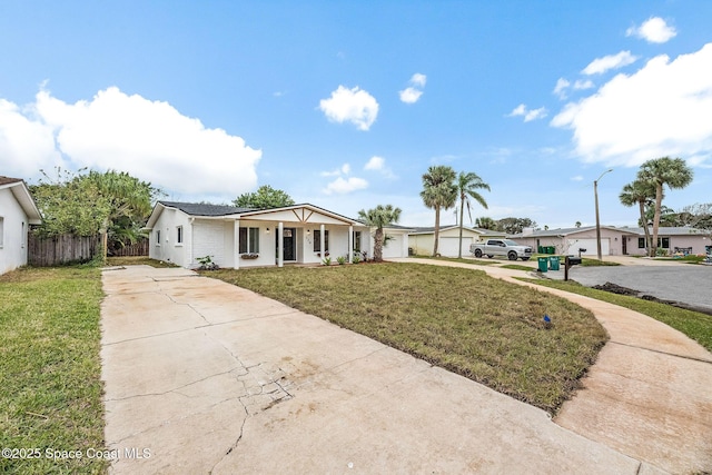 ranch-style house with a garage, a front lawn, and covered porch