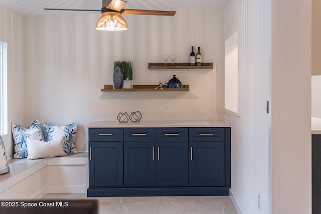 bar featuring ceiling fan and blue cabinets