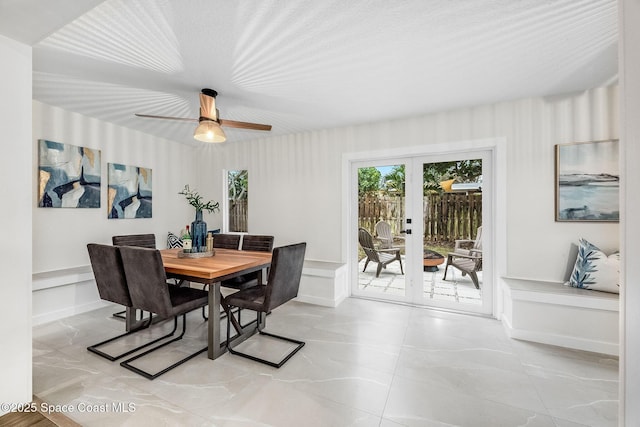 dining space with ceiling fan and french doors