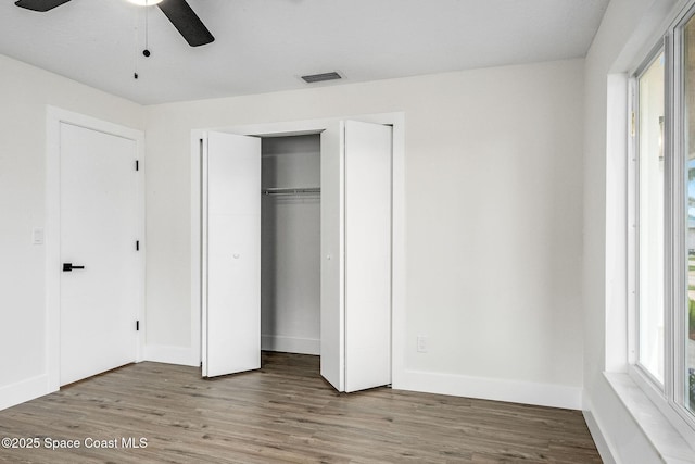 unfurnished bedroom with wood-type flooring, a closet, and ceiling fan