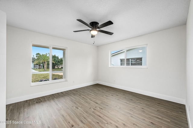 spare room featuring ceiling fan, wood-type flooring, and a textured ceiling