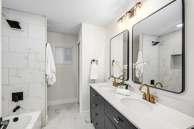 bathroom with vanity, tiled shower / bath combo, and a textured ceiling