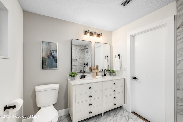 bathroom with vanity, a textured ceiling, a shower, and toilet