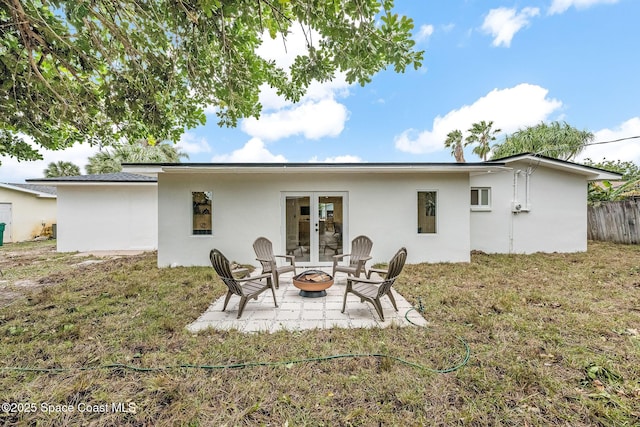 back of house featuring a yard, a patio, and a fire pit