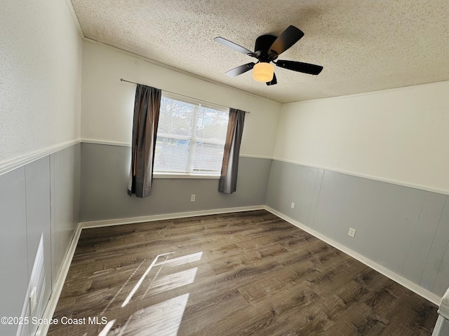 spare room featuring wood-type flooring, ceiling fan, and a textured ceiling