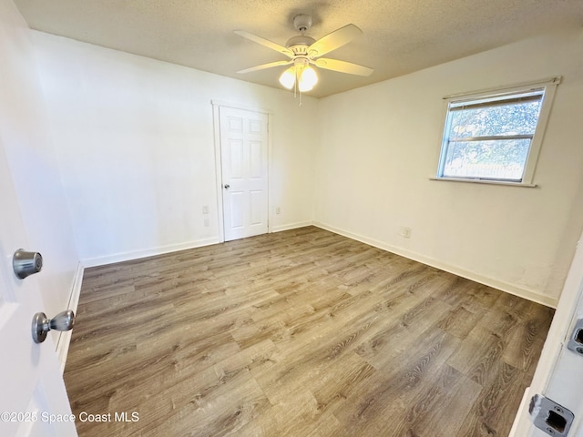 unfurnished room with ceiling fan, light hardwood / wood-style floors, and a textured ceiling