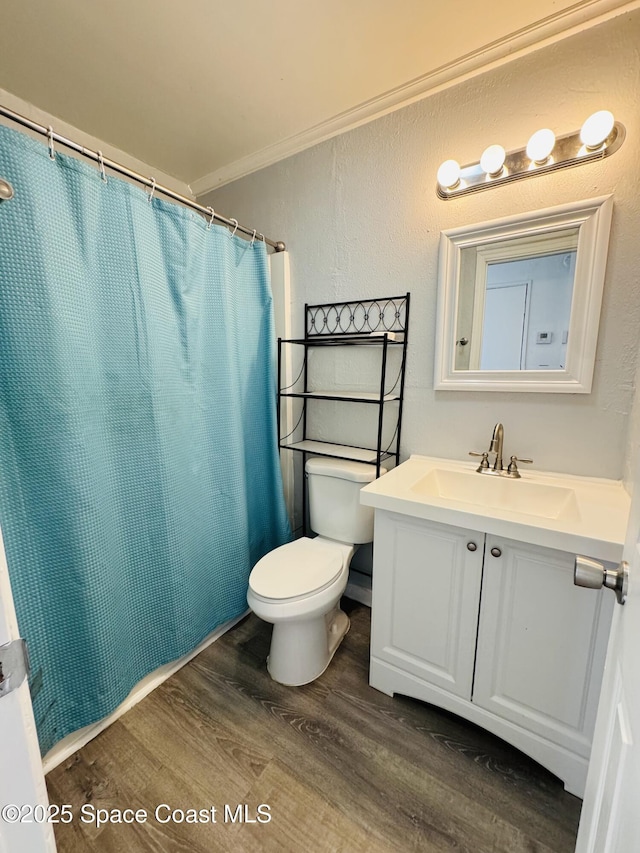 bathroom featuring hardwood / wood-style floors, vanity, ornamental molding, curtained shower, and toilet