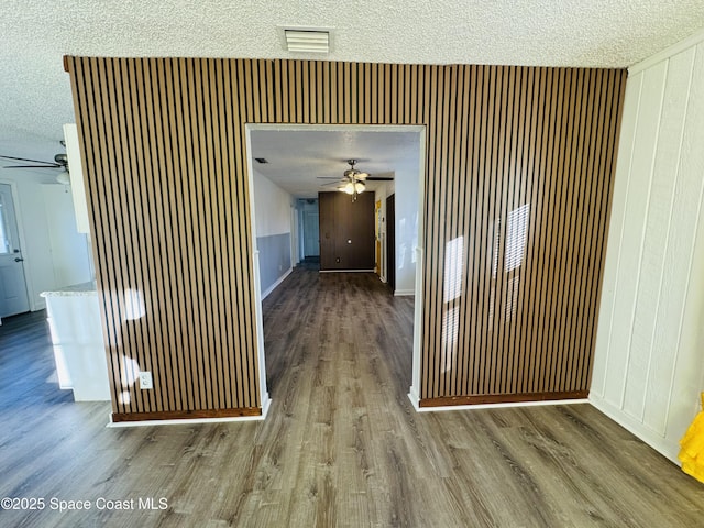 corridor with hardwood / wood-style floors and a textured ceiling