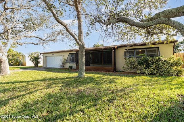 view of front of home with a garage, a front lawn, and a sunroom